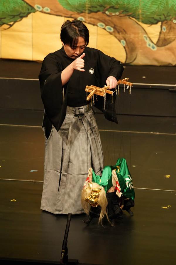 Kazuma Yuki manipulating a lion that brings good luck and fortune